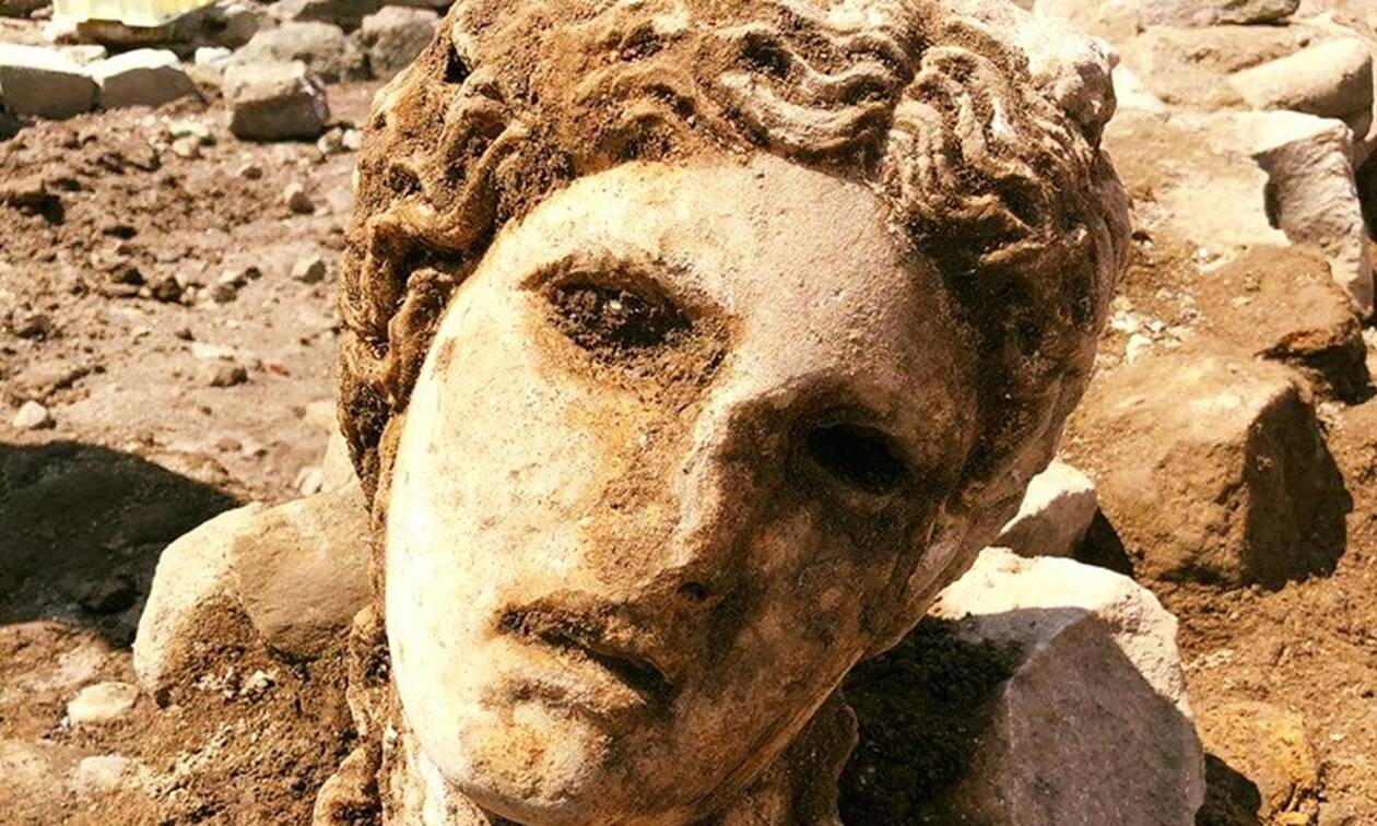 Αρχαιολόγοι έπειτα από ανασκαφές στην «καρδιά» της Ρώμης ανακάλυψαν ένα τεράστιο μαρμάρινο κεφάλι του θεού Διονύσου  Οι αρχαιολόγοι πραγματοποιούσαν ανασκαφές γύρω από τα ερείπια του μεσαιωνικού τείχους όταν βρήκαν το μαρμάρινο κεφάλι, το οποίο πιστεύουν πως αντικατοπτρίζει τον Διόνυσο και ενδεχομένως αποτελεί μέρος ενός μεγάλου αγάλματος.  «Οι αρχαιολόγοι έκαναν ανασκαφές σε ένα μεσαιωνικό τείχος όταν είδαν, κρυμμένο μέσα στη γη, ένα κεφάλι από λευκό μάρμαρο. Ήταν χτισμένο μέσα στο τείχος, συνιστώντας κατασκευαστικό υλικό, όπως συνέβαινε συχνά τον Μεσαίωνα. Μόλις ανασύρθηκε από το έδαφος, αποκαλύφθηκε όλο το μεγαλείο της ομορφιάς του. Το πρόσωπο είναι εκλεπτυσμένο, ευγενικό, στοιχεία που μας κάνουν να πιστεύουμε πως θα μπορούσε να απεικονίζει τον Διόνυσο», ανέφερε σε ανακοίνωση το Archaeological Park of the Colosseum.  «Η Ρώμη συνεχίζει να μας εκπλήσσει κάθε μέρα. Το κεφάλι του αγάλματος είναι σε εξαιρετική κατάσταση. Είναι ένα αριστούργημα», σχολίασε από την πλευρά της η δήμαρχος της Ρώμης, Virginia Raggi.  GALLERY d2-57.jpg 01	Σύμφωνα με τον Claudio Parisi Presicce, διευθυντή των αρχαιολογικών μουσείων της Ρώμης, το κεφάλι χρονολογείται μεταξύ 1ου αιώνα π.Χ. και 2ου αιώνα μ.Χ. Facebook/Parco archeologico del Colosseo    Σύμφωνα με τον Claudio Parisi Presicce, διευθυντή των αρχαιολογικών μουσείων της Ρώμης, το κεφάλι χρονολογείται μεταξύ 1ου αιώνα π.Χ. και 2ου αιώνα μ.Χ.  «Τα κενά μάτια, που πιθανώς ήταν γεμισμένα με γυαλί ή πολύτιμους λίθους, τοποθετούν χρονολογικά το κεφάλι στους πρώτους αιώνες της Ρωμαϊκής Αυτοκρατορίας. Η επιφάνεια δεν είναι εντελώς ορατή επειδή ακόμη δεν έχει καθαριστεί προσεκτικά. Πιστεύουμε πως ενδεχομένως υπάρχουν ακόμη ίχνη του αρχικού χρώματος διατηρημένα στο στεφάνι γύρω από το μαλλιά», σημείωσε ο ίδιος.     15 SHARES