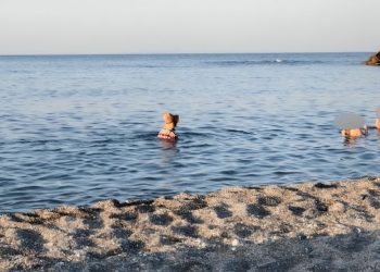 Δεν άντεξε λεπτό ούτε καν για να ξεντυθεί – Βούτηξε στη θάλασσα με τα ρούχα, καπέλο και σκαρπίνι… (ΕΙΚΟΝΕΣ)